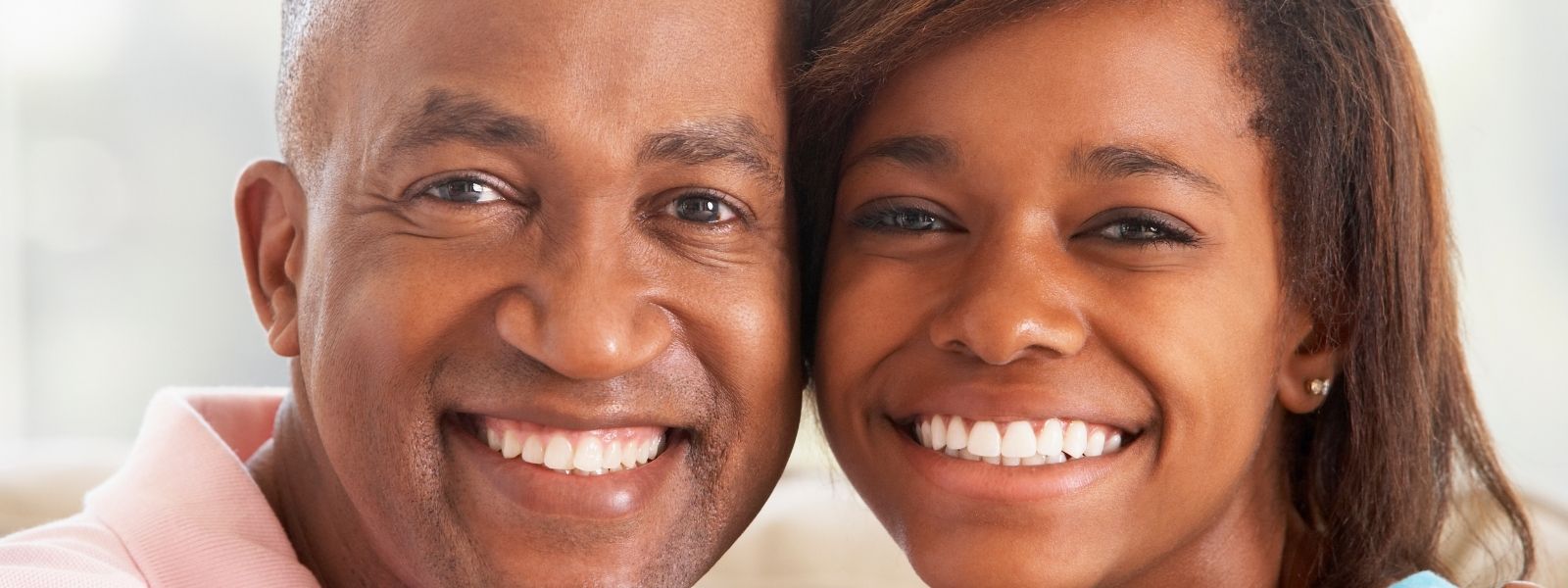 Pretty two dark skinned people smiling.